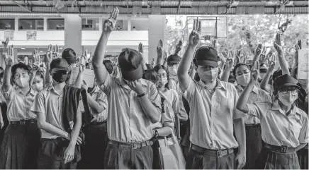  ?? [ADAM DEAN/THE NEW YORK TIMES] ?? Students flash a three-fingered salute from the “Hunger Games” books and movies at a protest in Bangkok on July 31. Street rallies across the country are urging the armed forces and their allies to withdraw from politics and respect human rights.