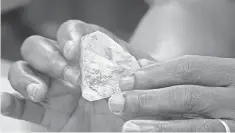  ?? AP ?? Sierra Leone’s President Ernest Bai Koroma holds the “Transparen­t Gem” at a meeting with delegates from Kono district, where the diamond was found. Kono residents hope the district’s efforts to recover from a civil war will improve when the diamond is...