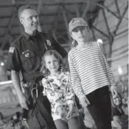  ??  ?? Firefighte­r Tony Palato with Ellie Johnson and Katie Johnson.