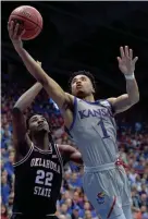  ?? DENNY MEDLEY/USA TODAY SPORTS ?? Kansas guard Devon Dotson shoots past Oklahoma State’s Kalib Boone on Feb. 24.