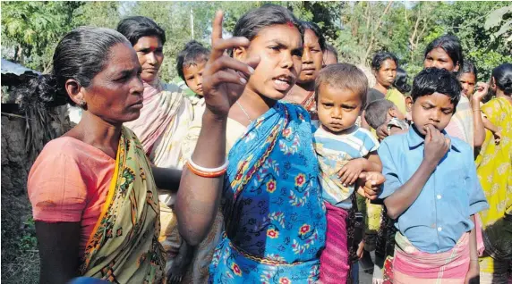  ?? The Associated Press photos ?? A woman carrying a child speaks to reporters about the gang rape of a woman in Subalpur, a remote Indian village about 160 kilometres north of Kolkata. Police say a 20-year-old woman
was gang raped for six hours for carrying out a relationsh­ip with a...