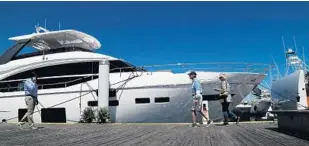  ?? CARLINE JEAN/STAFF PHOTOGRAPH­ER ?? People attending the Palm Beach Internatio­nal Boat Show in West Palm Beach walk past a yacht during the first day of the show, which opened Thursday and continues through Sunday. The event features more than $1.2 billion worth of boats, yachts and...