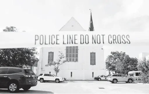  ?? Stephen B. Morton / Associated Press ?? Police tape surrounds the parking lot behind the AME Emanuel Church as FBI forensic experts work the crime scene Friday in Charleston, S.C. Dylann Storm Roof, 21, is accused of killing nine people during a Wednesday night Bible study at the church.