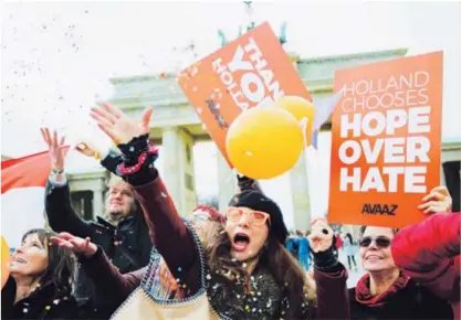  ?? AP ?? Miembros de la red AVAAZ celebraron ayer los resultados de las elecciones en Holanda enfrente de la puerta de Brandeburg­o, en Berlín.