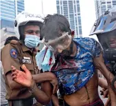  ?? ?? A policeman and a civilian help an anti-government protester who was beaten up by government supporters. (Right) A supporter of the wruling party runs after an anti-government demonstrat­or. — reuters, ap