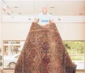  ?? CLARK HODGIN/THE NEW YORK TIMES ?? John Tyler Pace holds a Karastan rug in his father’s store in North Carolina. The mill that produced the “wonder rug of America”is closing.