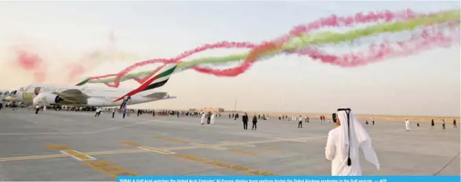 ??  ?? DUBAI: A Gulf Arab watches the United Arab Emirates’ Al-Fursan display team perform during the Dubai Airshow yesterday in the Gulf emirate. — AFP