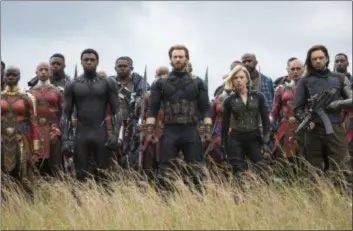  ??  ?? Danai Gurira, left, Chadwick Boseman, Chris Evans, Scarlet Johansson and Sebastian Stan portray heroes about to fight together in Wakanda in a scene from “Avengers: Infinity War.”