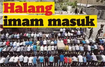  ??  ?? PENDUDUK menunaikan solat di luar pekarangan Masjid Al-Aqsa yang dikawal ketat tentera.