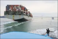  ?? Eric Risberg / Associated Press ?? On the bow of a Golden Gate Ferry a man takes a picture of a container ship as it heads toward the San Francisco-Oakland Bay Bridge in California.