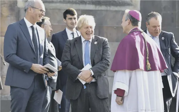  ?? ?? 0 Irish minister for foreign affairs, Simon Coveney, left, and British Prime Minister Boris Johnson chat with the clergy following a service to mark the centenary of Northern Ireland