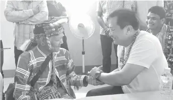 ??  ?? House Speaker Pantaleon Alvarez shakes the hand of Datu Gibang Apoga of the Ata Manobo who led his tribal warriors in joining the New Peoples Army for 28 years before his formal surrender in Talaingod, Davao del Norte.