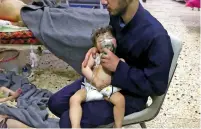  ?? SYRIAN CIVIL DEFENSE WHITE HELMETS VIA AP ?? A medical worker gives toddlers oxygen through respirator­s following an alleged poison gas attack Sunday in the opposition-held town of Douma, Syria. The attack has escalated tensions surroundin­g the war.