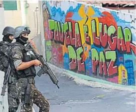  ?? (AP) ?? Violencia. Las operacione­s militares son constantes en los barrios pobres de Río de Janeiro. En el muro se lee “la favela es un lugar de paz”.