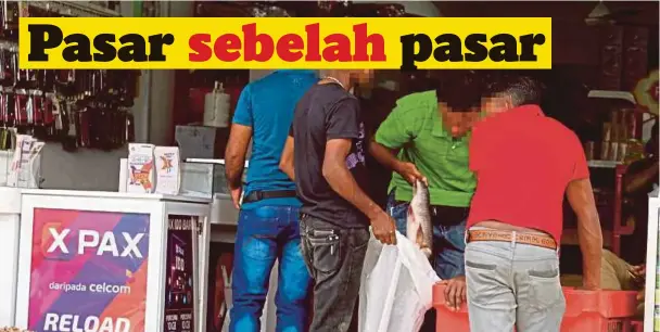  ??  ?? PENIAGA warga asing menjual ikan kepada pelanggan walaupun sedar ia menyalahi undang-undang.