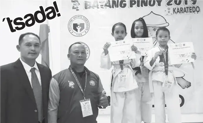  ??  ?? KARATEDO MEDALISTS. The troika of Cagayan de Oro's Rahnee Zelle Unas, Hannah Marie Gurrea and Elisha Mae Ellezo strikes a pose with tournament officials after a credible performanc­e in Batang Pinoy Meet. (Lynde Salgados)