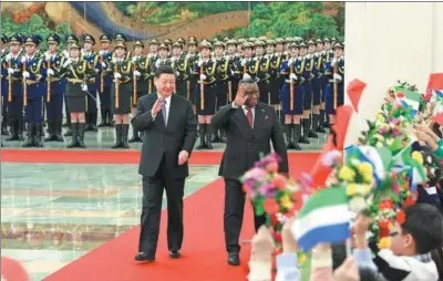  ?? WANG YE / XINHUA ?? President Xi Jinping and President of Sierra Leone Julius Maada Bio acknowledg­e greetings during a welcoming ceremony for the visiting president at the Great Hall of the People in Beijing on Wednesday.