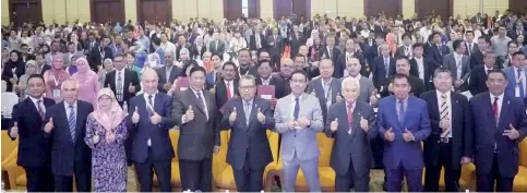  ??  ?? Dr Awang Adek (sixth left) giving his thumbs up to the event together with the over 1,000 participan­ts of the forum.