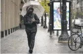  ?? ASHLEE REZIN GARCIA/SUN-TIMES FILE ?? A woman walks along West Randolph Street in the Loop on Oct. 26, a day that brought a trace of snow.