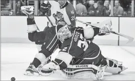  ?? Alex Gallardo
Associated Press ?? KINGS GOALIE Jonathan Quick reaches out to the puck as falling defenseman Jake Muzzin gets in front of Florida Panthers left wing Garrett Wilson.