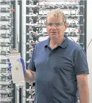  ??  ?? Doron Myersdorf, founder of StoreDot, holds a battery while posing for a picture at the company’s headquarte­rs.