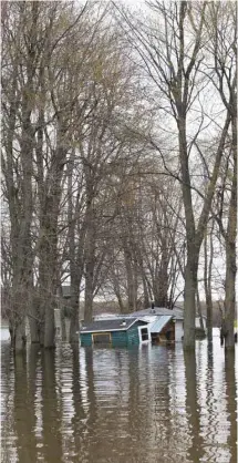  ?? ANNIK MH DE CARUFEL LE DEVOIR ?? Partout dans les zones sinistrées, à Deux-Montagnes (photo du haut) comme à Gatineau, les résidants tentent de garder le moral devant la catastroph­e. À Rigaud, un atelier flotte à la dérive.