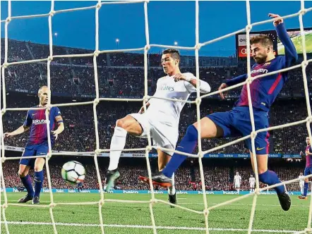  ?? — Reuters ?? No stopping him: Real Madrid’s Cristiano Ronaldo scoring the first goal in the La Liga match against Barcelona at the Nou Camp on Sunday.