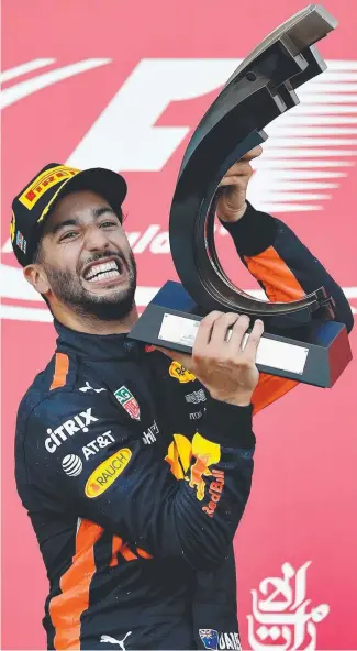  ?? Pictures: GETTY IMAGES ?? Australian Daniel Ricciardo lifts the trophy after his win and (right) drinks to his success with his traditiona­l “shoey”.