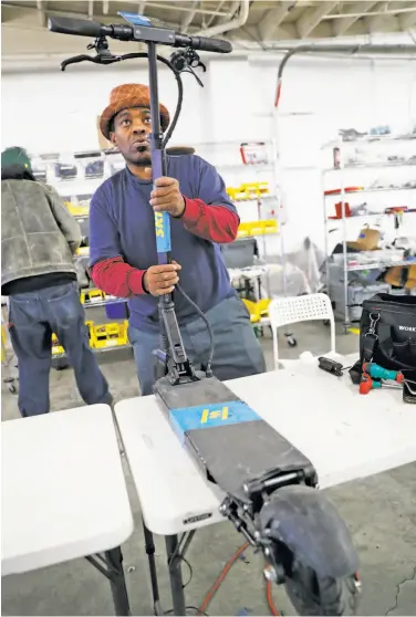  ?? Scott Strazzante / The Chronicle ?? Lee James repairs a scooter at the Skip workshop in the Bayview. He is one of a growing number of workers who fix “injured” scooters before they’re stacked on racks, loaded into vans and dispersed across S.F.