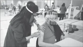  ?? Tribune News Service/los Angeles Times ?? Denker Elementary School educationa­l resource aide Raymundo Armagnac, 65, gets his COVID-19 vaccinatio­n from nurse practition­er Mary Ann Topico on Feb. 17 in Los Angeles.