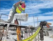  ??  ?? WILLIAM FULLER III works on his art installati­on at his home in the mining town of Trona.