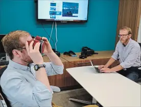  ?? P. SOLOMON BANDA THE ASSOCIATED PRESS ?? Nick Harrell holds up a pair of virtual reality goggles that are used in therapy to treat his fear of flying. Behavioral HealthScie­ntist Sam Hubley is at right.