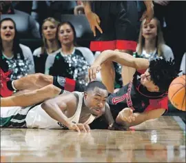 ?? Al Goldis Associated Press ?? MICHIGAN STATE’S Lourawls Nairn, left, and Rutgers’ Geo Baker hit the floor as they go after a loose ball during overtime at East Lansing, Mich.