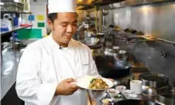  ??  ?? A chef presenting a vegetarian version of pad kra phao, made with a meat substitute stir-fried with chili and basil, at a restaurant in Bangkok.