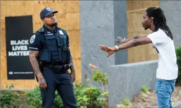  ?? Andrew Caballero-Reynolds/AFP via Getty Images ?? A protester speaks with a police officer Wednesday in Black Lives Matter Plaza near the White House in Washington.