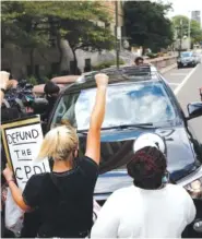  ?? AP PHOTO/JAY LAPRETE ?? Protesters block a car with Ohio House Speaker Larry Householde­r in it from leaving the Federal Courthouse after Householde­r was arrested in a $60 million federal bribery probe Tuesday in Columbus, Ohio.