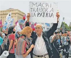  ?? AP/NATACHA PISARENKO ?? Protesters hold up signs at a rally against the rising cost of public transport services and utilities.