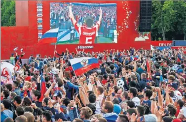  ??  ?? VIBRA EL PUEBLO. Aficionado­s rusos siguen en pantallas gigantes uno de los partidos de Rusia.