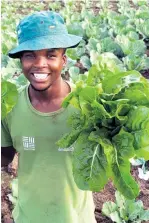  ?? ?? Siphomandl­a Mthembu showing off some of their fresh produce