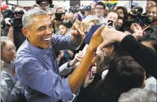  ?? Jacquelyn Martin / Associated Press ?? Former President Barack Obama smiles as he greets Democratic volunteers in a surprise appearance in Fairfax Station, Va., on Monday.