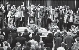  ?? Herald photo by Ian Martens ?? Former classmates, teachers, friends and family stand alongside Logan’s casket as they sing “The Churchill Victory Song” during the service.