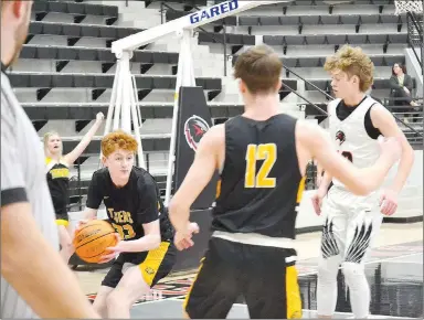  ?? ?? Prairie Grove senior Cole Cash (black No. 33) recovered the rebound and headed back up court as Blackhawk junior Evan Anderson and Tiger Landon Semrad keep a close eye on the ball.