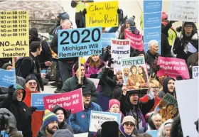  ?? Dale G. Young / Associated Press ?? Demonstrat­ors gather at the state Capitol before going inside as Michigan legislator­s consider bills during a “lame duck” session in Lansing.