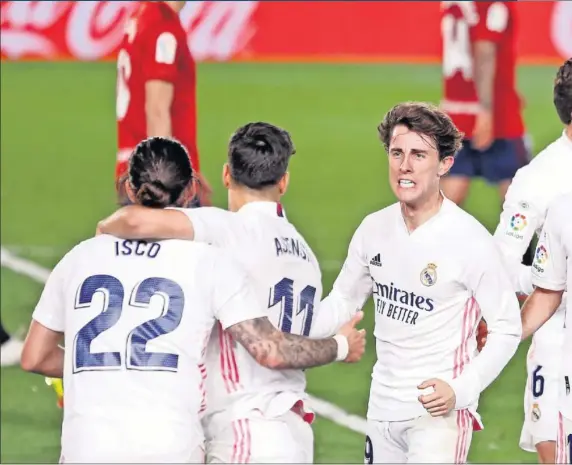  ??  ?? Varios jugadores del Madrid van a abrazarse a Isco, que lanzó muy bien el córner que remató Militao de cabeza para acabar con el 0-0 del marcador.