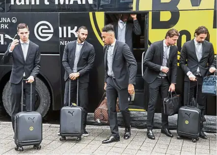  ?? — AFP ?? Flying off: Borussia Dortmund players getting off from their team bus before their flight to Spain to face Real Madrid today.