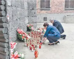  ??  ?? Η Πολωνή πρωθυπουργ­ός ανάβει κερί στο Αουσβιτς.