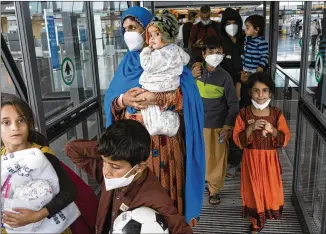  ?? JOSE LUIS MAGANA/ASSOCIATED PRESS ?? Families evacuated from Kabul, Afghanista­n, walk through the terminal as they prepare to board a bus upon arrival at Washington Dulles Internatio­nal Airport, in Chantilly, Va.