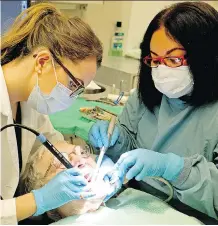 ?? LARRY WONG ?? Dental patient Wilma Amirault receives treatment from Dr. Fern Leavens, left, and dental assistant Lalaine Jovellanos at the Glenrose Rehabilita­tion Hospital on Wednesday.
