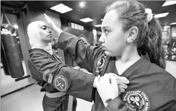  ??  ?? Kuwaiti Asma Hasnawi (left), a Kajukenbo hybrid martial art assistant-master, practises with her daughter Riham.