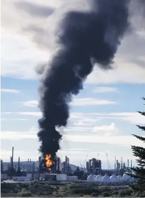  ?? NATE GUIMOND / THE CANADIAN PRESS ?? Fire and a plume of smoke rise from an Irving Oil refinery after an explosion in Saint John, N.B., on Monday. There were no deaths and only four suffered minor injuries.